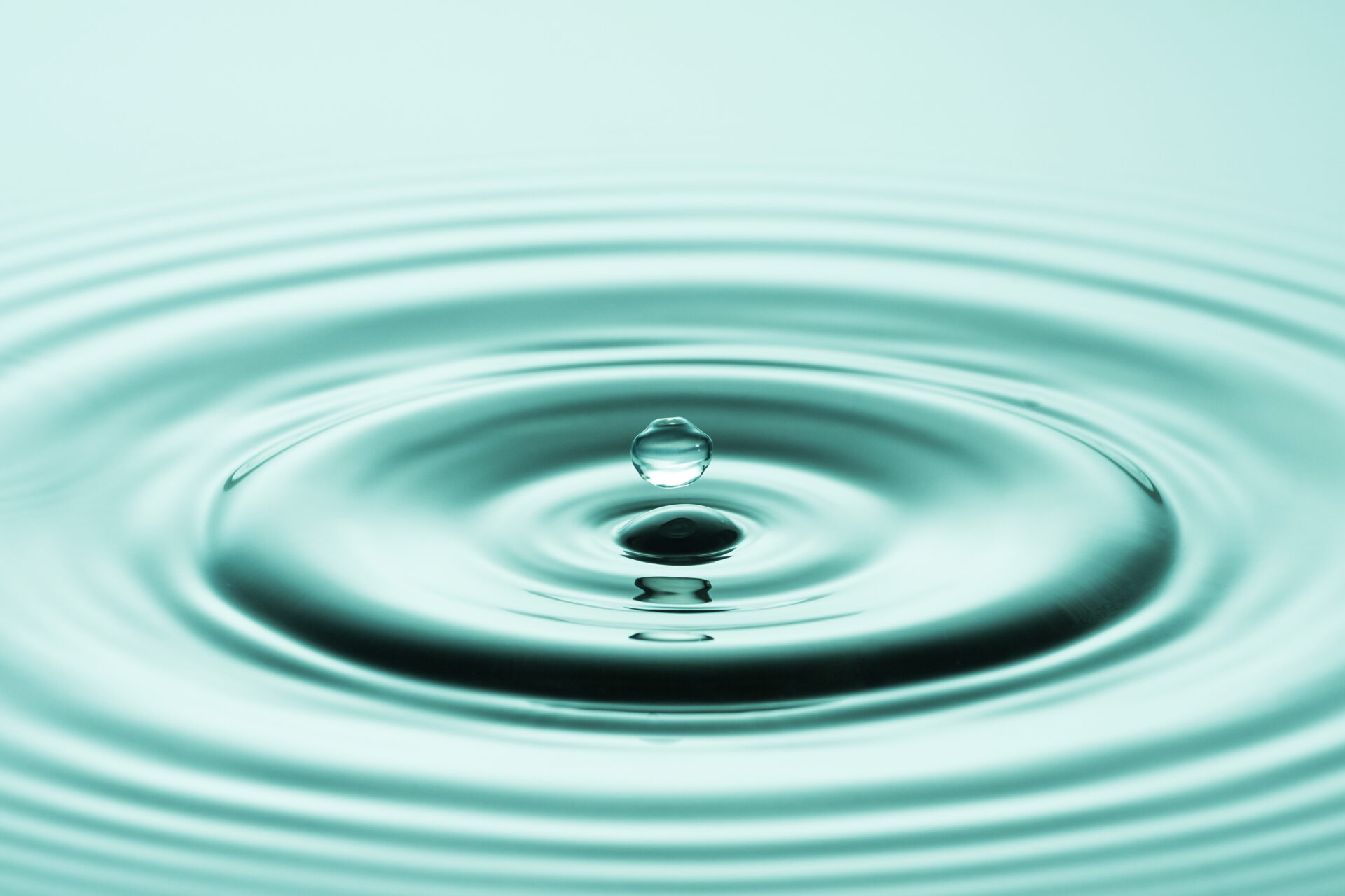 Goutte d’eau formant des cercles dans une eau vert pur — illustration du blog sophrologie et hypnose à Andernos-les-Bains
